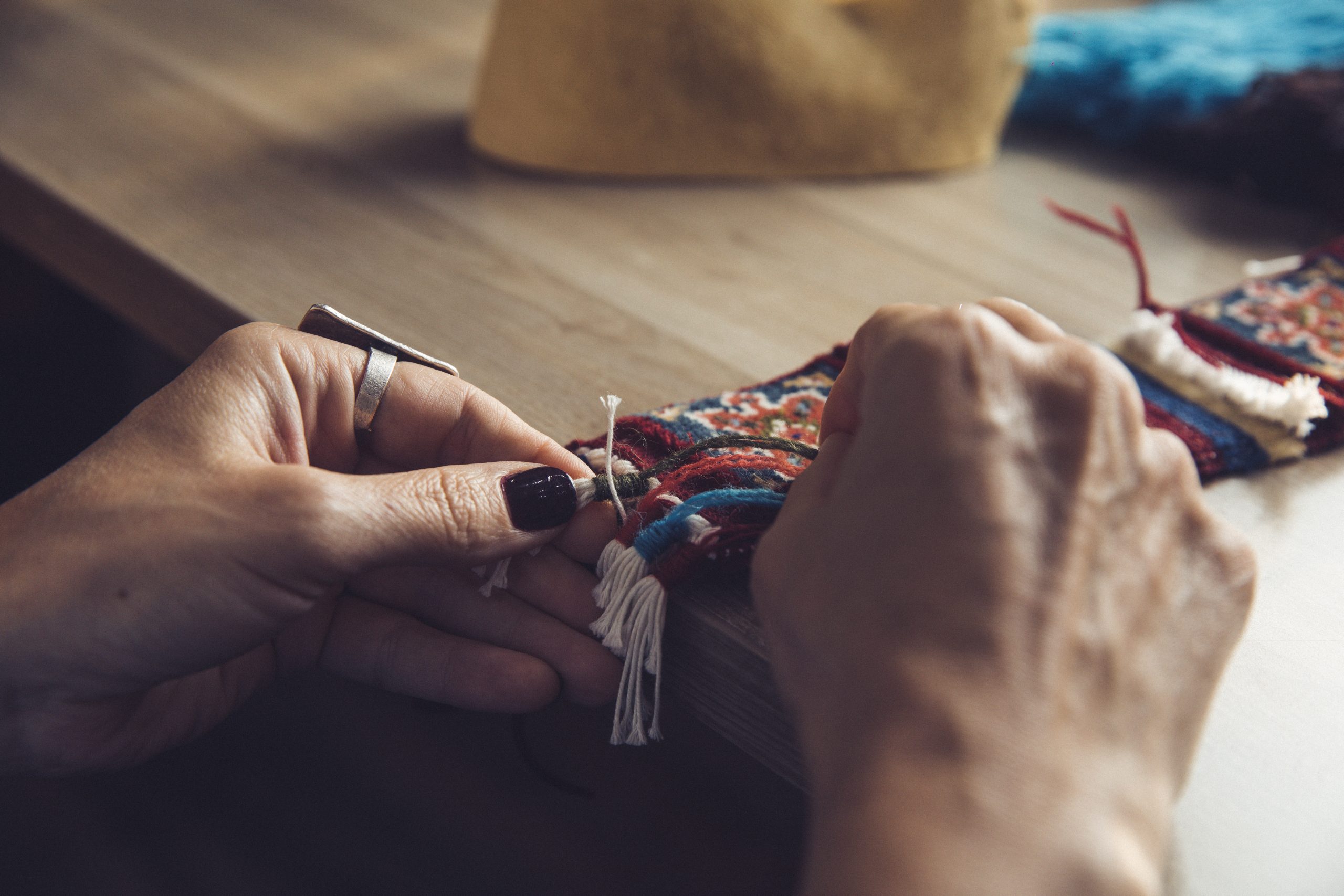 woman knitting carpet with eastern ornaments